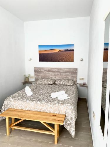 Un dormitorio con una cama y una mesa de madera. en Apartamento Andalucia, en Tarifa