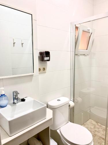 Un baño blanco con inodoro y lavabo. en Apartamento Andalucia, en Tarifa