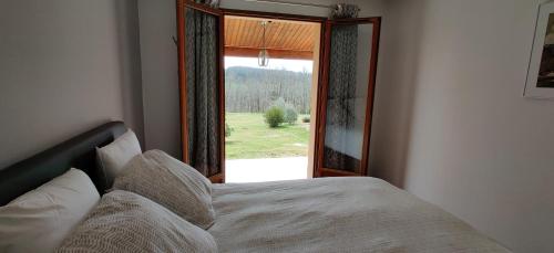 1 dormitorio con cama y ventana grande en Villa Padam, en Monsac