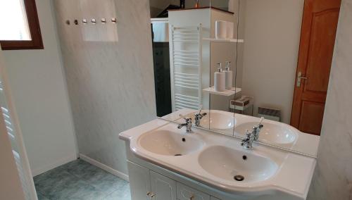 Baño blanco con lavabo y espejo en Villa Padam, en Monsac