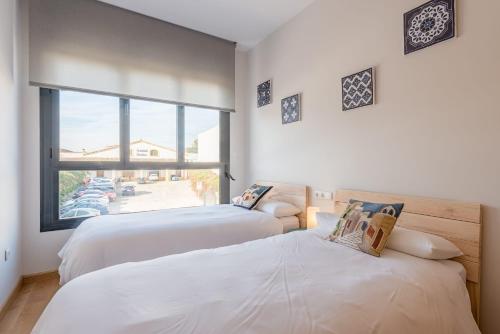 ヘレス・デ・ラ・フロンテーラにあるSherryflat Abrantes - Parkingの大きな窓付きの客室で、ベッド2台が備わります。