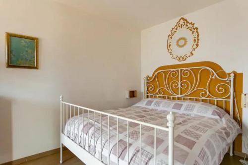a bedroom with a white bed with a wooden headboard at Casa con terrazzo vista Lago - LAKEHOLIDAY IT in Castel di Tora