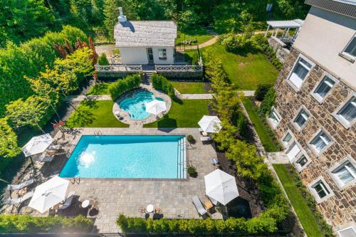 an aerial view of a house with a swimming pool at StoneHaven Le Manoir - Relais & Châteaux in Sainte-Agathe-des-Monts