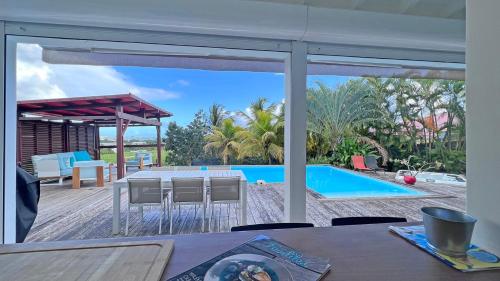 a dining room with a view of a pool at Wood Chic in Baie-Mahault