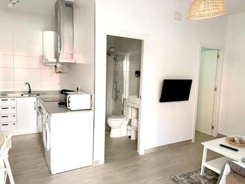 a white kitchen with a sink and a toilet at Apartamento Puerta Al Mar in Tarifa