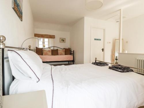 a bedroom with a large white bed and a room with a bedzinski at Slate Cottage in Helland