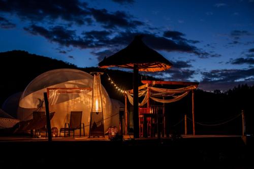 a tent with an umbrella in the dark at The Bubble Valley Piet Retief in Piet Retief