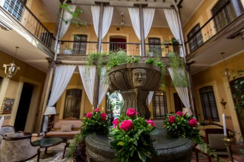 a living room with a large planter with pink flowers at Mansion Alcazar in Cuenca