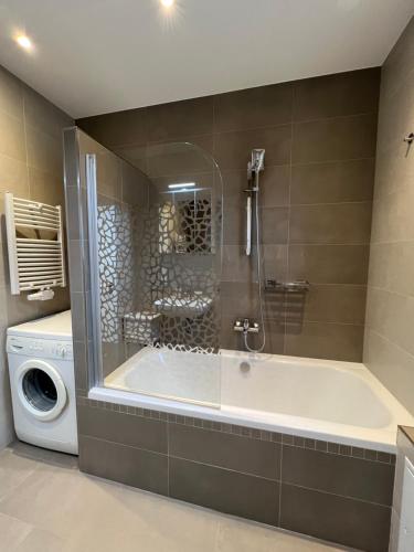 a bathroom with a tub and a washing machine at Ferienwohnung Möwenblick in Wilhelmshaven