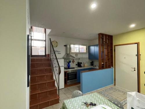 a kitchen with a staircase leading into a kitchen with a table at Belvedere Lacinio -Casa Vacanze-Villaggio Casarossa in Crotone