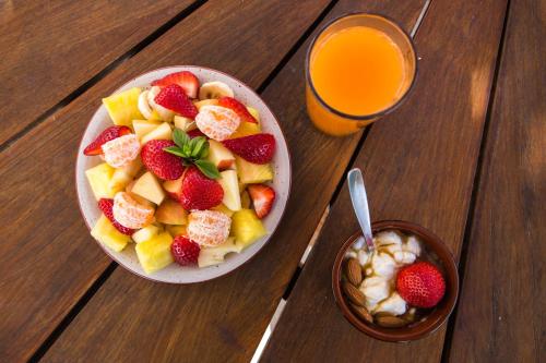 una ciotola di frutta, una ciotola di cereali e un bicchiere di succo d'arancia di Arodamos Studios Apartments a Kíssamos