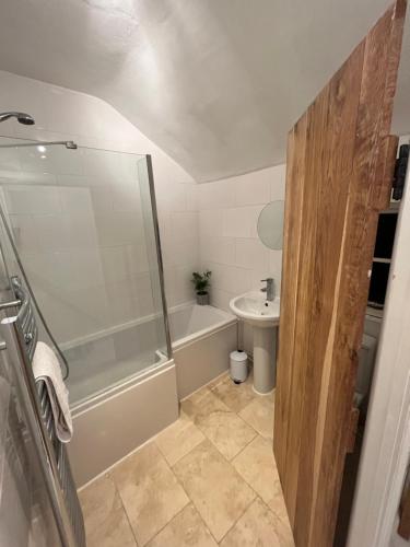 a bathroom with a shower and a toilet and a sink at Bay Cottage, Hot Tub in Snitterfield