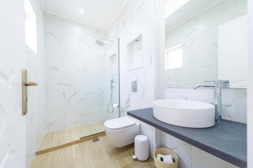 een witte badkamer met een wastafel en een toilet bij Zante Oceana in Tsilivi