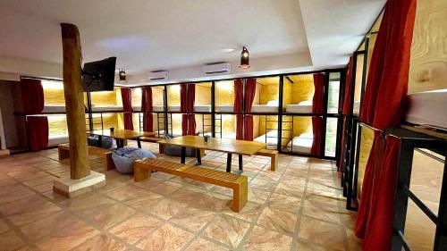 タルコレスにあるHotel Cerro Lodgeのテーブル、ベンチ、窓が備わる客室です。