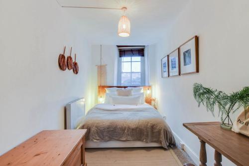 a bedroom with a bed and a wooden table at The Malthouse - Naturally styled central apartment in Cirencester