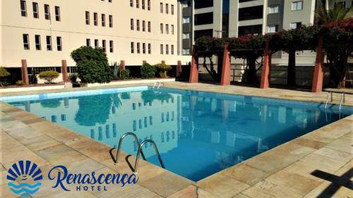 a swimming pool in front of a building at Atlântico Sul Renascença Hotel in Laguna