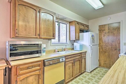 a kitchen with wooden cabinets and a white refrigerator at Home with Serene Deck in Twain Harte! in Twain Harte
