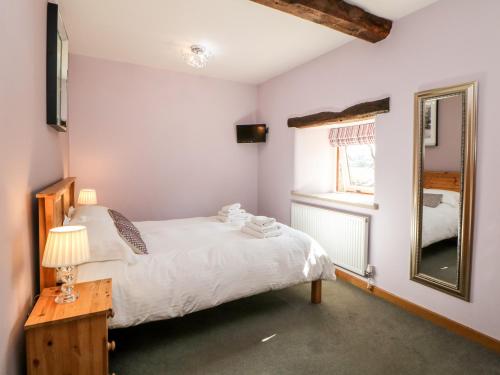 a small bedroom with a bed and a mirror at Broadway Barn in Millers Dale