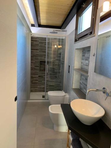 a bathroom with a toilet and a sink and a shower at Casa Rifa in Serramanna