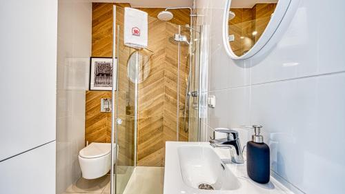 ein Badezimmer mit Dusche, Waschbecken und Toilette in der Unterkunft Apartament 57 Holiday Mountain Residence - 5D Apartamenty in Świeradów-Zdrój