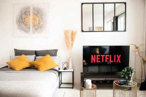 ein Schlafzimmer mit einem Bett und einem TV mit einem Netflix-Schild in der Unterkunft "LE PERSIAN" Studio à 3 min de la GARE, 10min du centre commercial, WIFI, PARKING in Courcouronnes