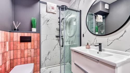 a bathroom with a shower and a sink and a mirror at Apartament przy Wyciągu 2 - 5D Apartamenty in Świeradów-Zdrój