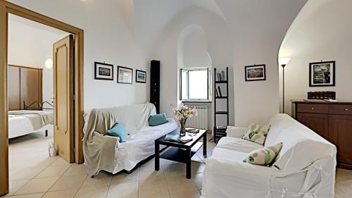 een woonkamer met twee witte banken en een tafel bij The Hidden Garden in Ravello