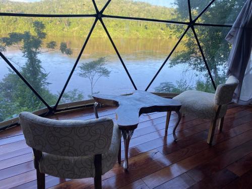 a room with a table and two chairs and a large window at La Mision Mocona - Lodge de Selva in Saltos del Moconá