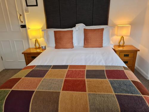 a bedroom with a bed with two lamps on tables at Ty Helyg Guest House in Brecon