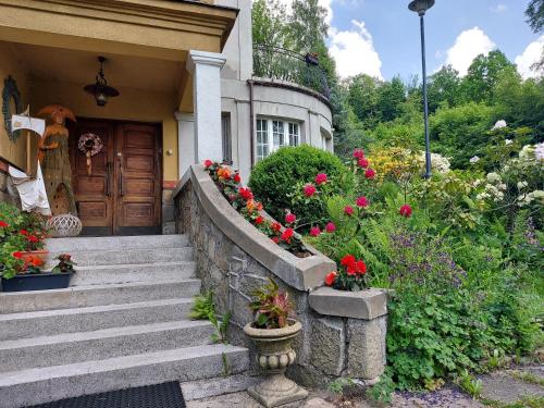 a house with stairs and flowers in front of it at Willa Marysin in Maków Podhalański