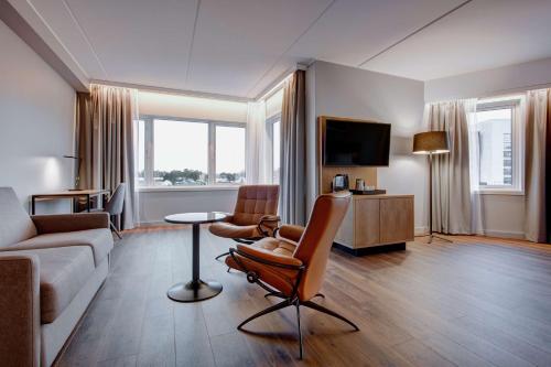a living room with a couch and a chair at Radisson Blu Hotel Nydalen, Oslo in Oslo