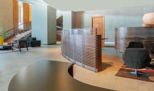 a lobby with a table and chairs and stairs at Sonesta Hotel Osorno in Osorno