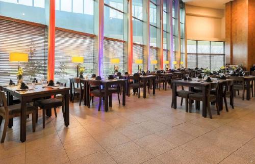 a dining room with tables and chairs and windows at Sonesta Hotel Osorno in Osorno