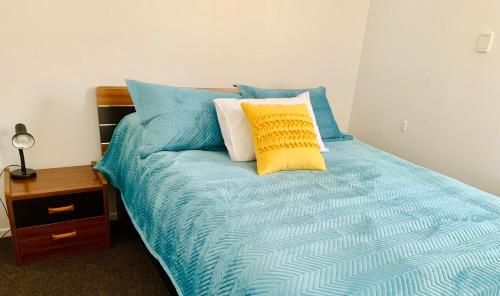 un letto con cuscini blu e gialli di Auckland Central Motel ad Auckland