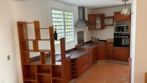a kitchen with wooden cabinets and a counter top at Magnifique Villa Domaine de Biglette in Baie-Mahault