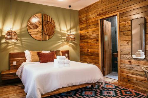 1 dormitorio con cama blanca y paredes de madera en Palmar Beach Lodge, en Bocas Town