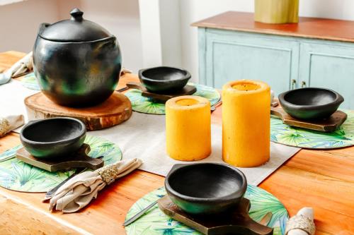 a table with black bowls and orange candles on it at Hotel Kuácara Campestre in Cajibío