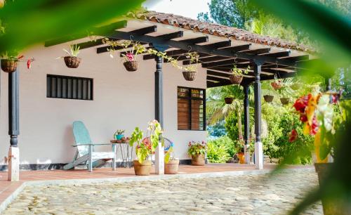 a pergola with potted plants on a patio at Hotel Kuácara Campestre in Cajibío