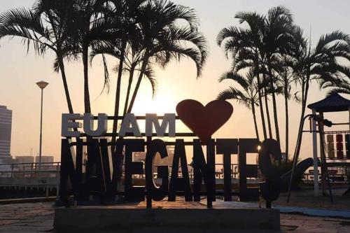 a heart statue in front of a playground with palm trees at Apartamento encantador na praia de Navegantes in Navegantes