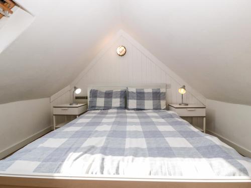 um quarto com uma cama de xadrez azul e branco em The Old Stable em Sherborne