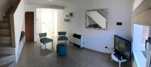 ein Wohnzimmer mit 2 Stühlen und einem TV in der Unterkunft Leams in Playa Unión