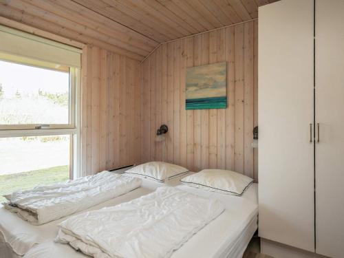 two beds in a room with a window at 8 person holiday home in Brovst-By Traum in Brovst