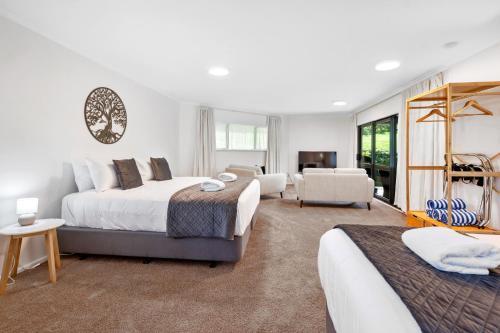 a bedroom with two beds and a living room at Acacia Heights - Garden Cottage - Taupo in Taupo
