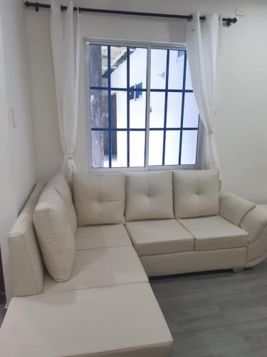 a white couch in a room with a window at Casa Hotel Alborada in San Antero
