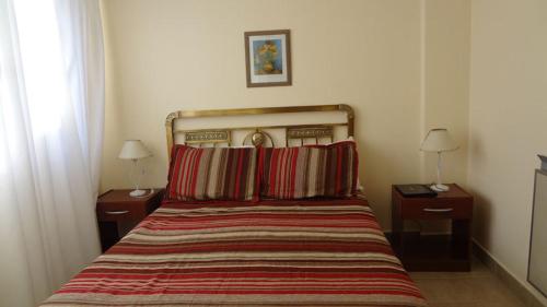 een slaapkamer met een bed met 2 nachtkastjes en 2 lampen bij Departamento del Mar in Mar del Plata