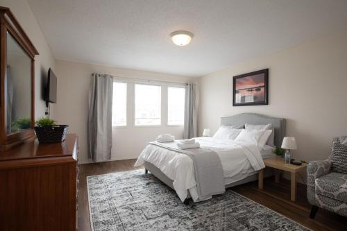 a bedroom with a bed and a chair and a window at Elegant 6 Bedroom House Near U of Manitoba in Winnipeg