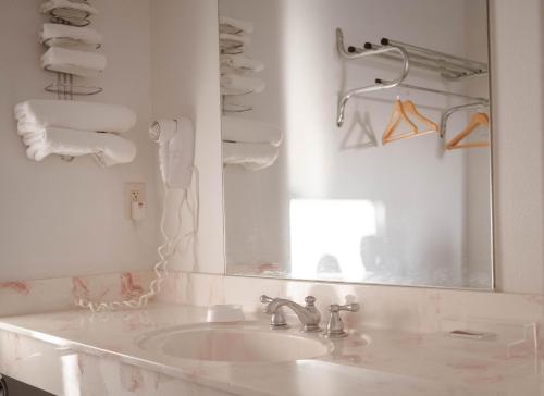 uma casa de banho branca com um lavatório e um espelho em Haysville Express Inn em Haysville