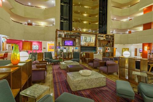 a lobby with a waiting area with chairs and tables at Camino Real Aeropuerto in Mexico City