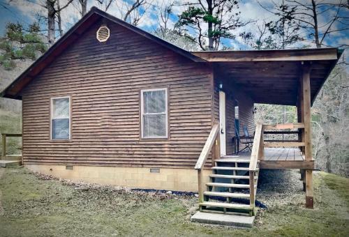 uma pequena casa com uma escada em frente em Cedar Creek Cabins #1 - Giant Spa Tub, Large Wooded Porch, Full Kitchen, 1 Bedroom em Eureka Springs