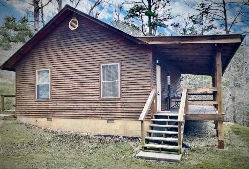 a small house with a staircase in front of it at Cedar Creek Cabins #1 - Giant Spa Tub, Large Wooded Porch, Full Kitchen, 1 Bedroom in Eureka Springs